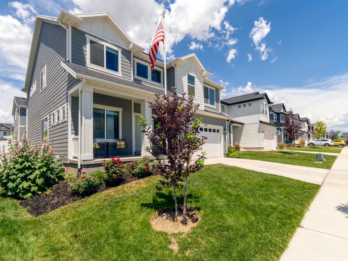 A suburban street of single-family homes with mature front lawns